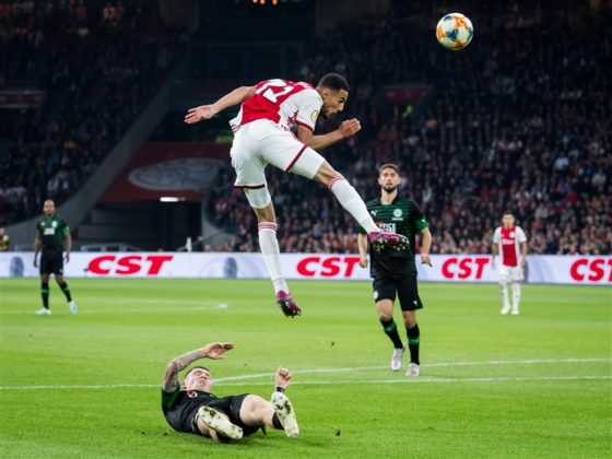 Noussair Mazraoui of Ajax leaps in the air as he is tackled by Groningen defender Django Warmerdam.